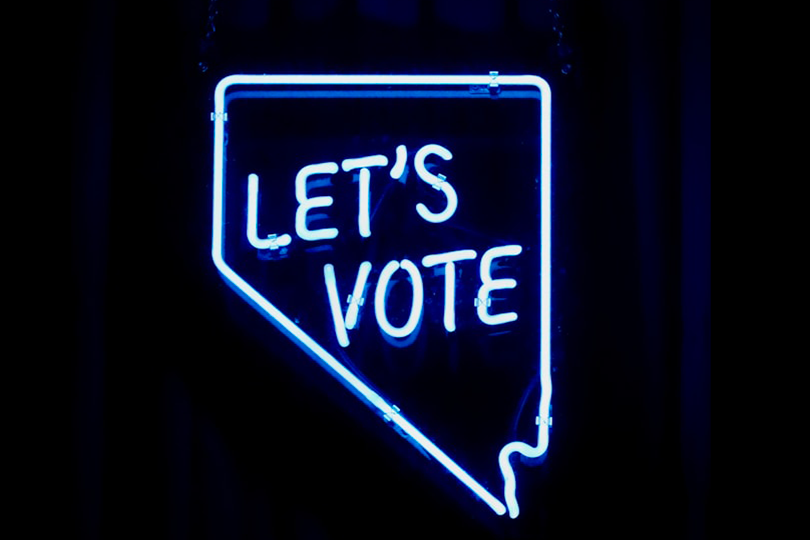 Blue neon on a black background displaying an invitation to vote