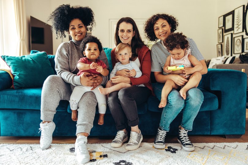 Photo of a trio of mothers each holding a child in their arms