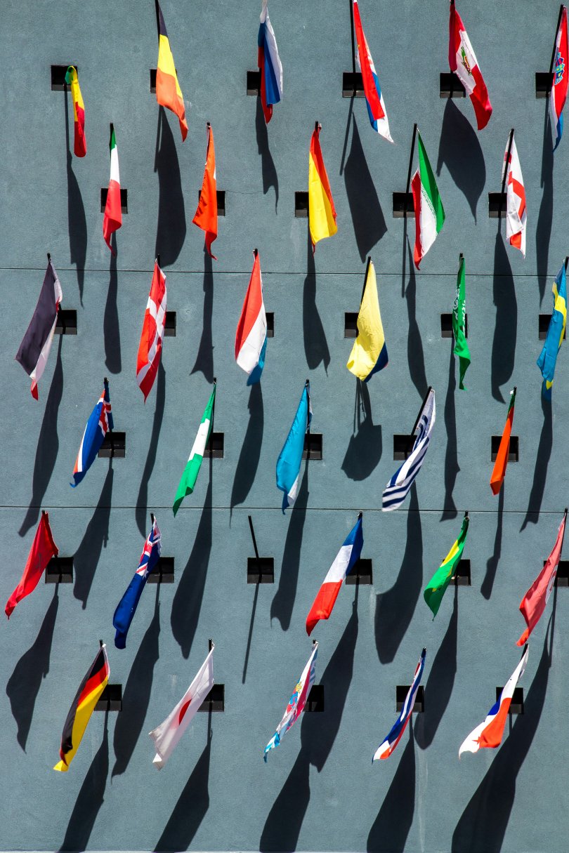 photo of national flags in assorted colors on the wall during the day