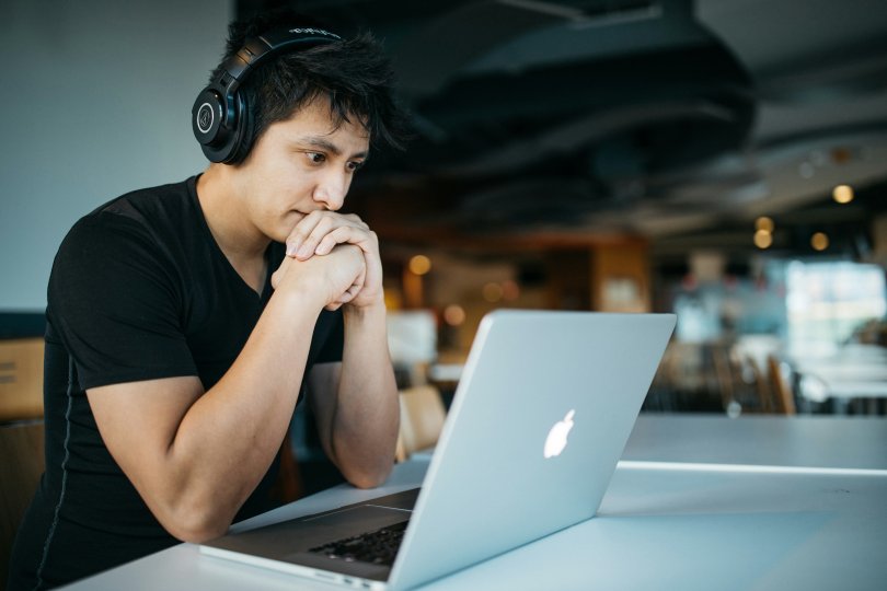 An anxious man looking at his computer